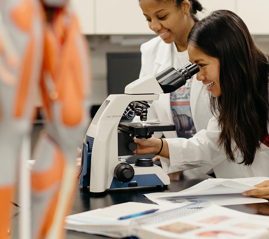Student looks into a microscope in a laboratory session.