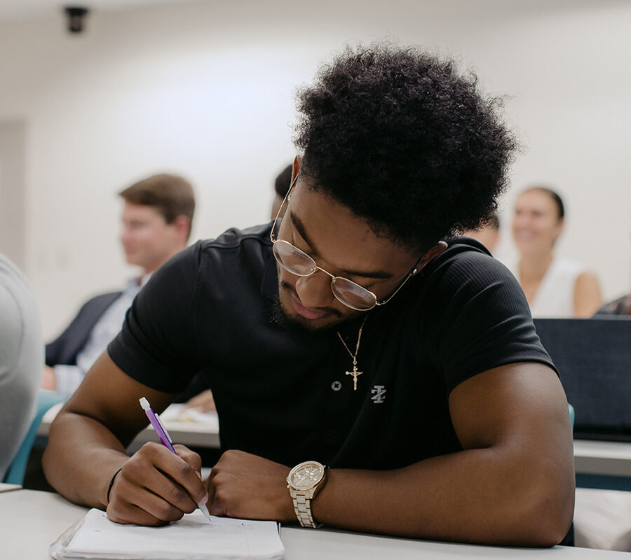 PBA student takes notes in class.